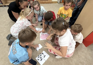Pięciolatki układają puzzle.