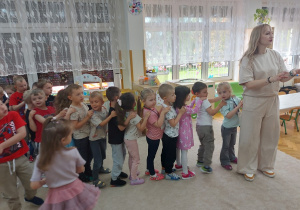 Dzieci ustawiają się w pociągu za Panią Pleciugą