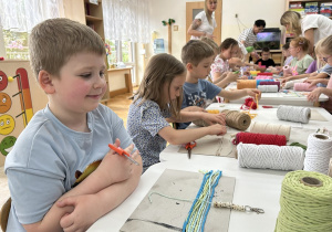 06 Dzieci przy stolikach ucinają kolorowe sznurki