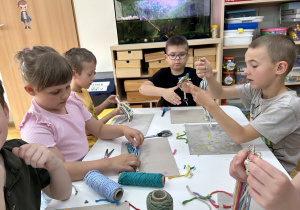10 Dzieci przy stoliku oglądają swoje breloczki