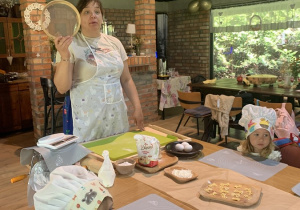 01 Warsztaty makaronowe; pani pokazuje dzieciom 3 letnim akcesoria potrzebne do robienia makaronu