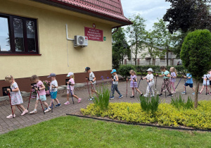 Dzieci spacerują z kijkami.