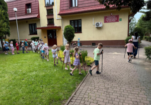 Dzieci idą z kijkami.
