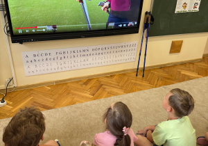 Dzieci oglądają filmik instruktażowy.