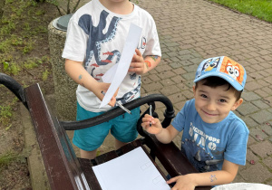 Chłopcy projektują na kartkach papieru.