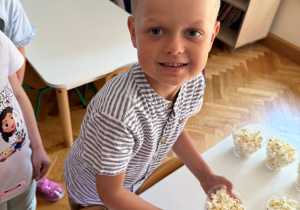 Chłopiec trzyma popcorn w rękach.