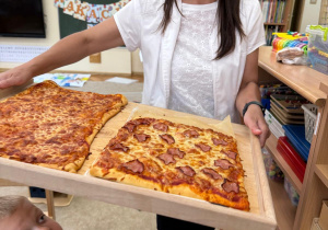 Pani przynosi nam upieczoną pizzę.