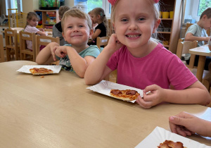 Dzieci zjadają pizzę.