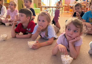 Dzieci zjadają popcorn.