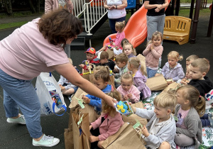 15 Pani podaje nagrodę chłopcu siedzącemu na kocu