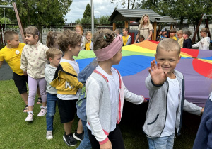 21 Dzieci idą w koło trzymając chustę animacyjną