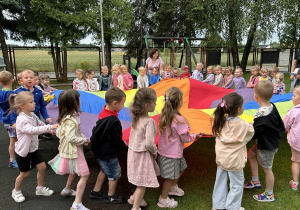 22 Dzieci z młodszych grup idą w koło trzymając chustę animacyjną