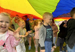 24 Uśmiechnięte dzieci bawią się pod chustą animacyjną