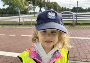 Dziewczynka w czapce policjanta.