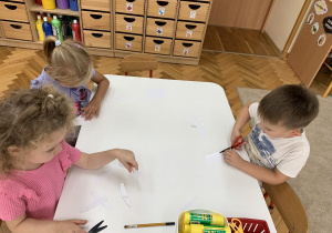 Dzieci wycinają nożyczkami paski.
