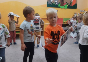 01. Dzieci chodzą po sali z gazetami.