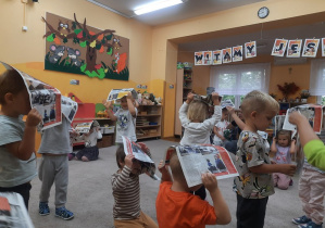 02. Dzieci mają gazety na głowach.