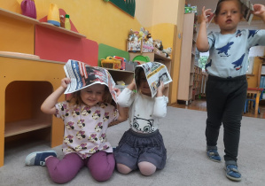 03. Dzieci mają gazety na głowach.