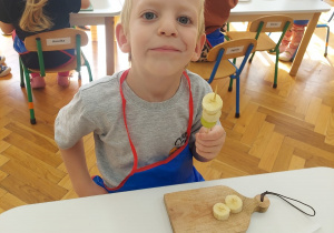 Chłopiec nabija owoce na patyczek.