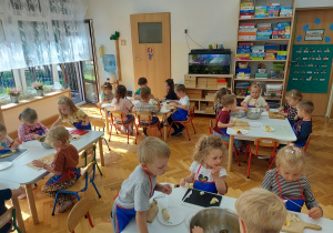 Dzieci w ciszy i skupieniu komponują swoje szaszłyki.