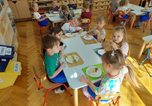 Zadowolone i uśmiechnięte Kropelki zajadają się owocowym deserem.