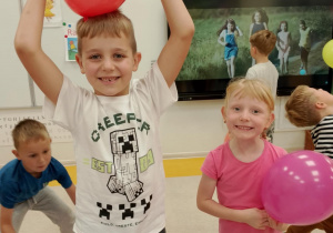 Uśmiechnięty chłopiec trzyma balon.
