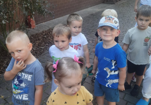 Dzieci idą na spacer trzymając węża