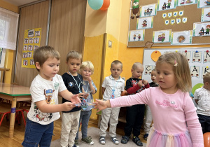 24. Dziewczynka wręcza prezent.