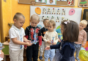 25. Dziewczynka wręcza prezent.