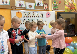 26. Dziewczynka wręcza prezent.