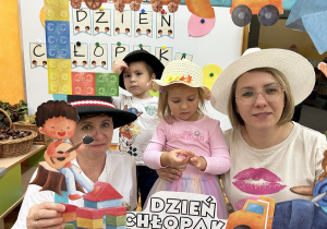 37. Panie z dziećmi w nakryciach głowy.