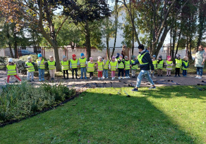Dzieci ustawione w szeregu słuchają i obserwują panią instruktor.