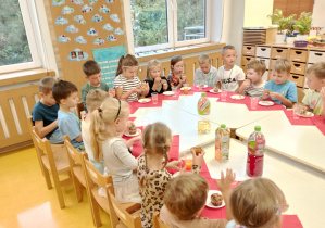 Dzieci siedzą wspólnie przy stole.
