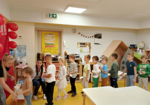 Dzieci stoją w kolejce po popcorn.