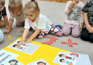 Dziewczynka przykleja ilustrację na plakacie