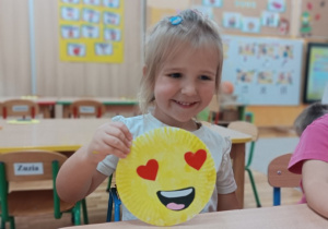 Dziewczynka pokazuje swoją pracę