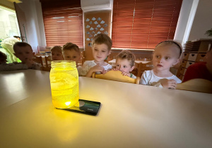 Zdziwione dzieci obserwują eksperyment.