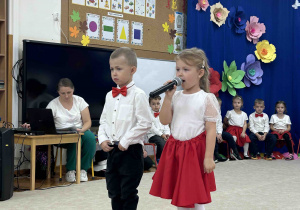 Dziewczynka i chłopiec witają gości.