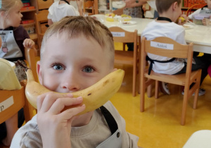 Chłopiec trzyma banana.