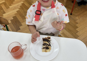 Dziewczynka zajada się naleśnikiem z owocami i sosem czekoladowym.