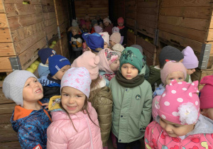 Dzieci oglądają skrzynie z jabłkami.