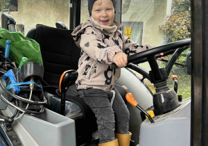 Uśmiechnięty chłopiec w traktorze.