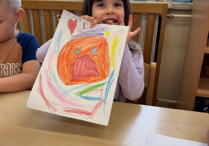 Dziewczynka prezentuje swoją pracę.