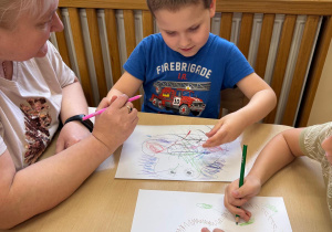 Chłopiec maluje określoną emocję.