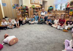 Dzieci siedzą w kole.