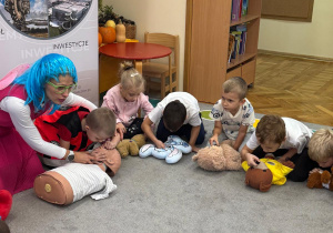 Pani ratownik uczy chłopca jak udzielać pierwszej pomocy.