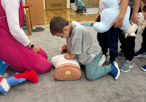 Chłopiec uciska manekina.