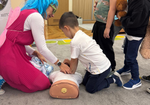 Chłopiec uciska manekina.