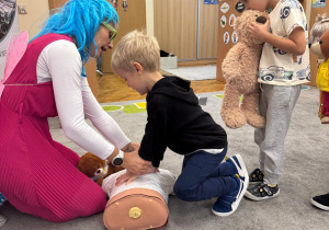 Chłopiec uciska manekina.