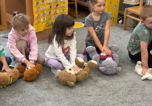 Dzieci ćwiczą na misiach uciski klatki piersiowej.